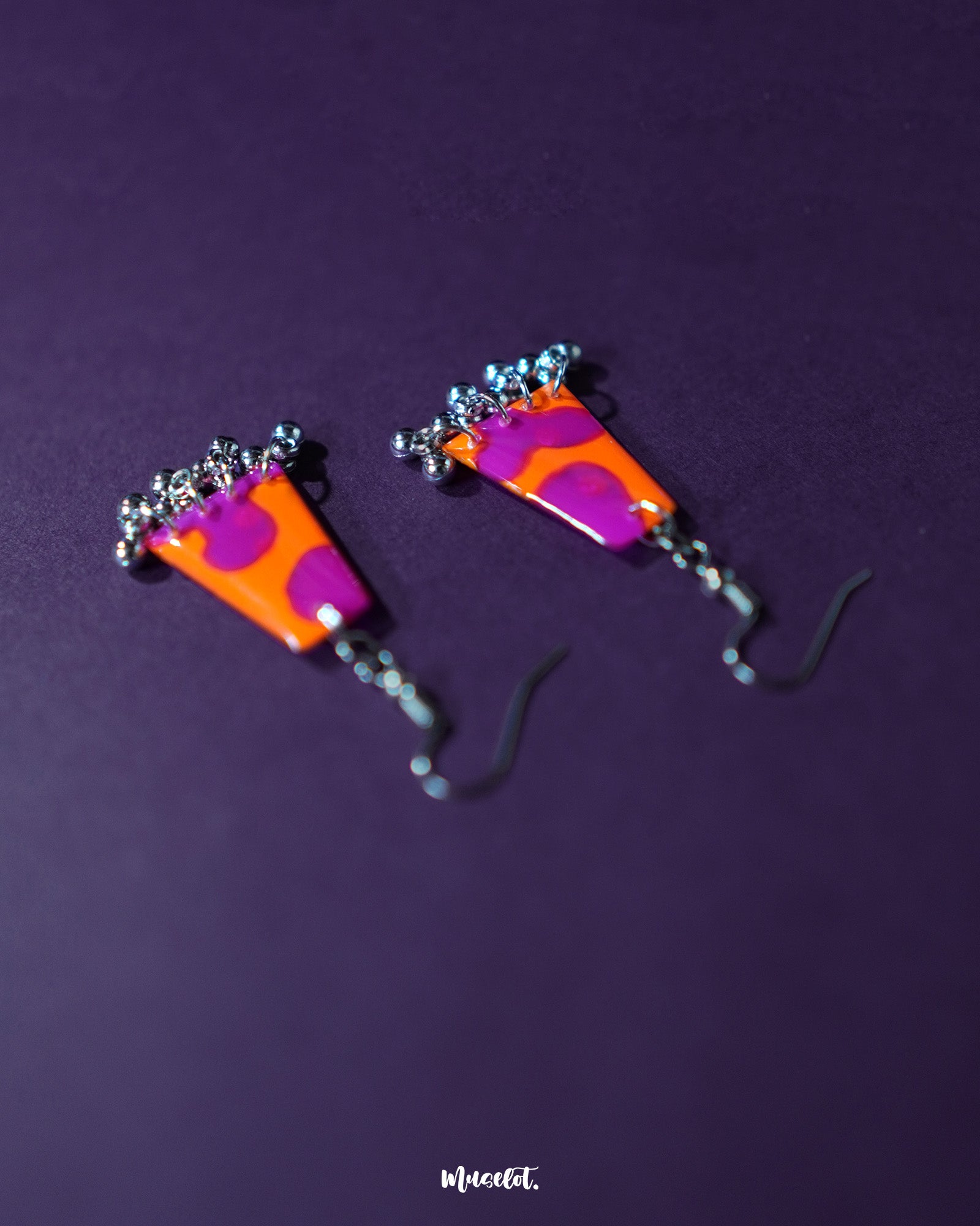 The Laalsavera earrings stand out with their elegant design, enhanced by a bold purple background, blending modern style with artistic flair – Muselot.