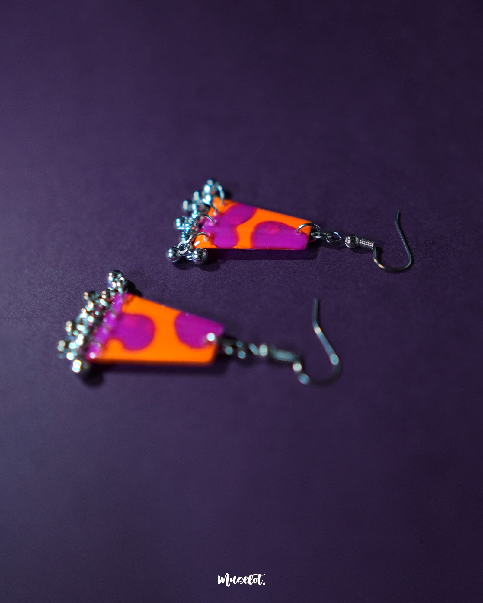 The Laalsavera earrings exude charm through their delicate design, beautifully set against a deep purple background, adding a touch of artistic sophistication – Muselot.