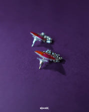 The Laalsavera stud earrings, delicately crafted and highlighted against a rich purple backdrop, bring a touch of sophistication — Muselot.