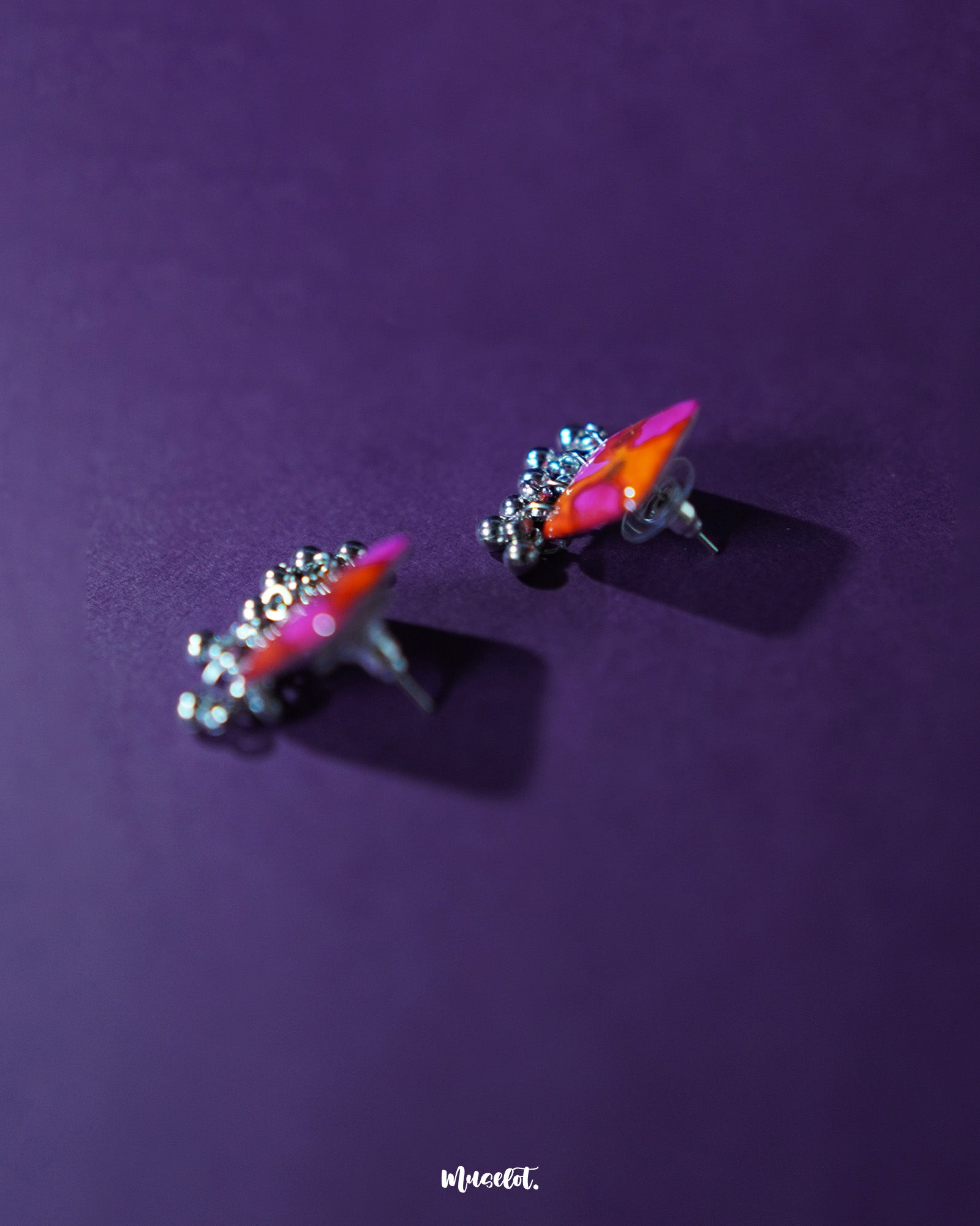 The Laalsavera stud earrings, set against a bold purple backdrop, offer a sleek and stylish look — Muselot.