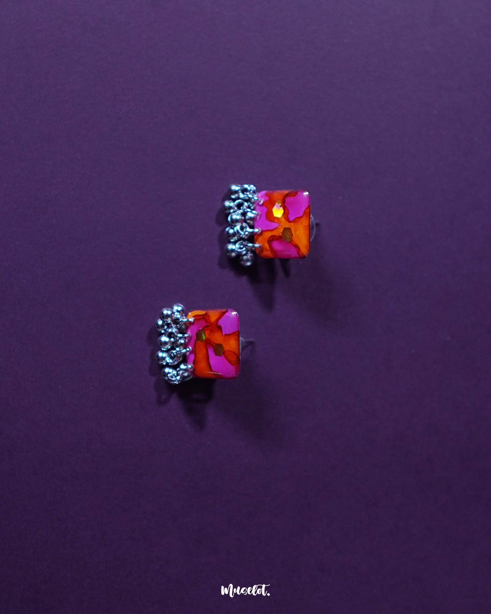 The Laalsavera stud earrings, with their intricate detailing, shine brightly against a soft purple background — Muselot.