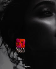A close-up shot of a model wearing the Laalsavera stud earrings with effortless grace, the bold background enhancing the earrings refined silhouette and artistic flair – Muselot