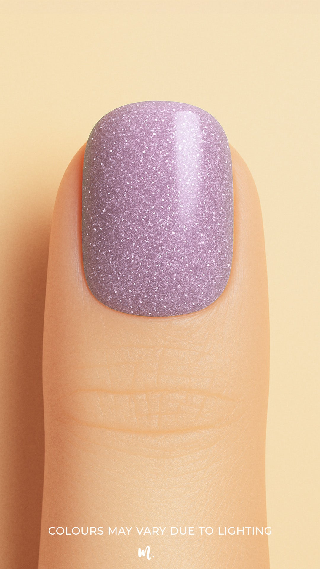 A close-up shot of a model’s finger wearing Lilac Dust Glitter nail stickies, showcasing a soft pastel lilac shade infused with fine glitter specks, creating a subtle yet elegant sparkle with a smooth, glossy finish – Muselot.