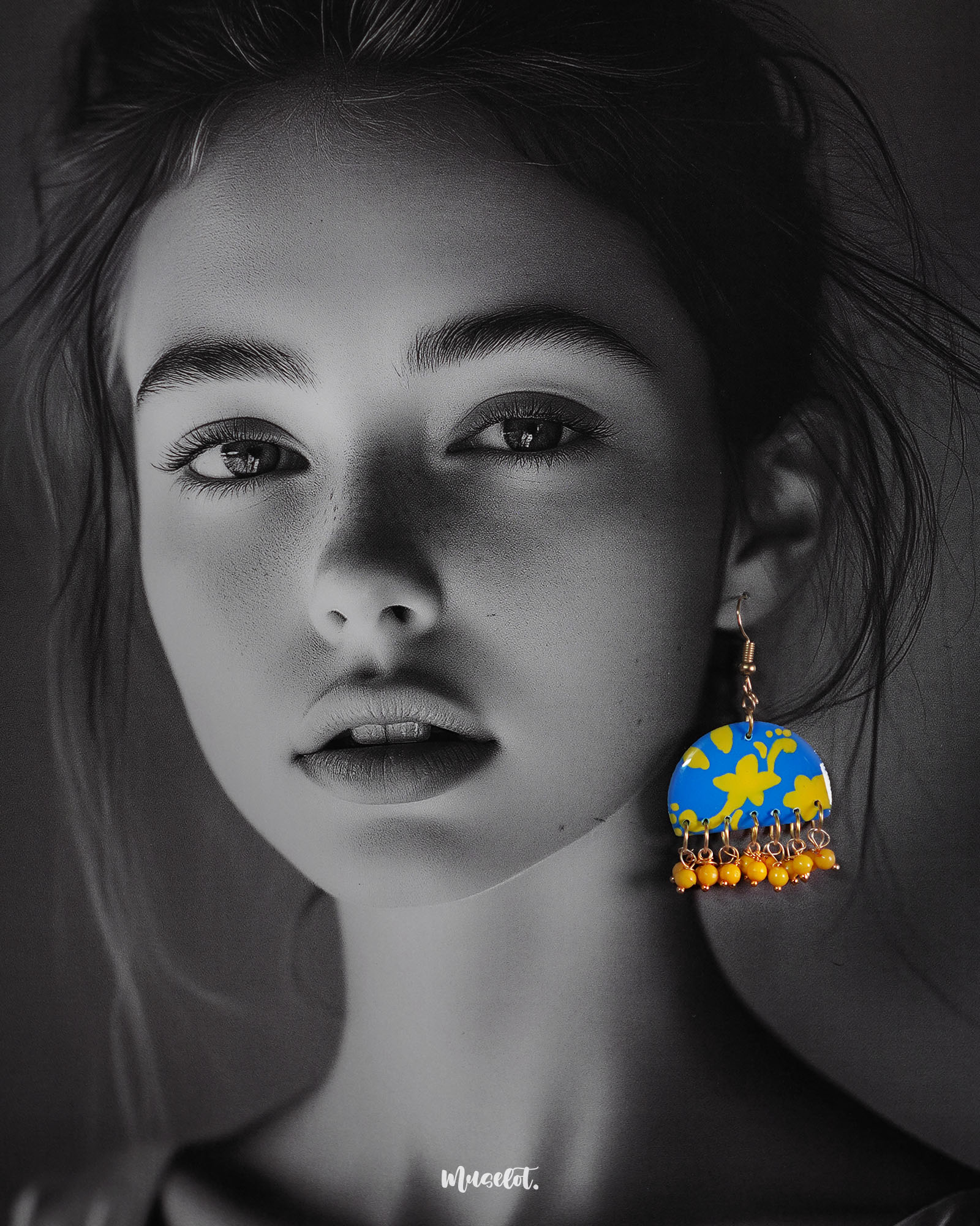 a model wearing Mahrosh blue and yellow hook earrings, with striking blue and yellow tones and intricate design elements that bring a fresh, elegant vibe to the ensemble — Muselot.