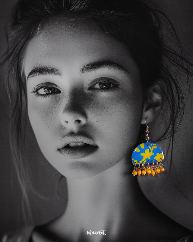 a model wearing Mahrosh blue and yellow hook earrings, with striking blue and yellow tones and intricate design elements that bring a fresh, elegant vibe to the ensemble — Muselot.