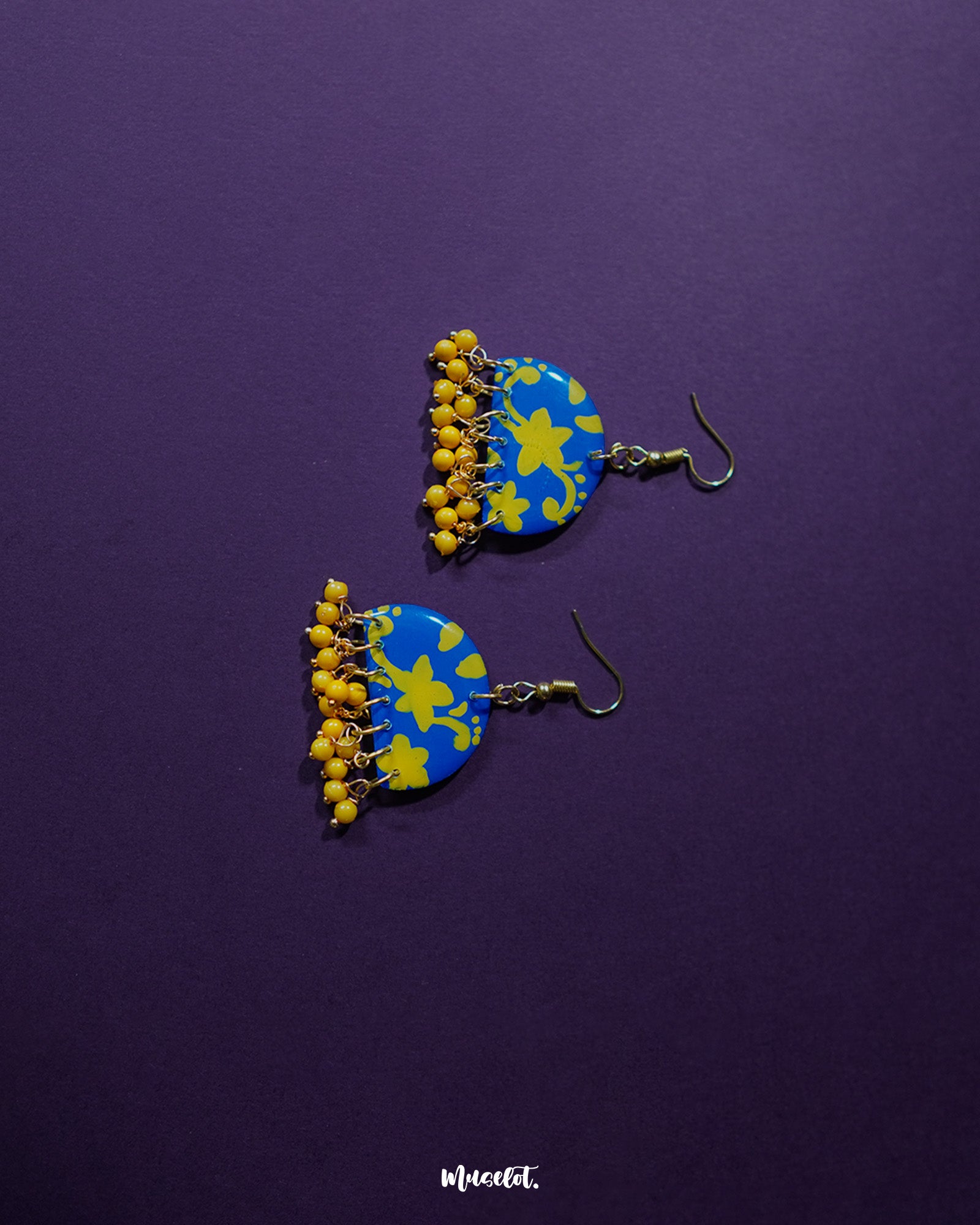 Mahrosh floral hook earrings, set against a rich purple background, featuring delicate floral patterns and intricate craftsmanship that enhance their timeless charm and elegance — Muselot.