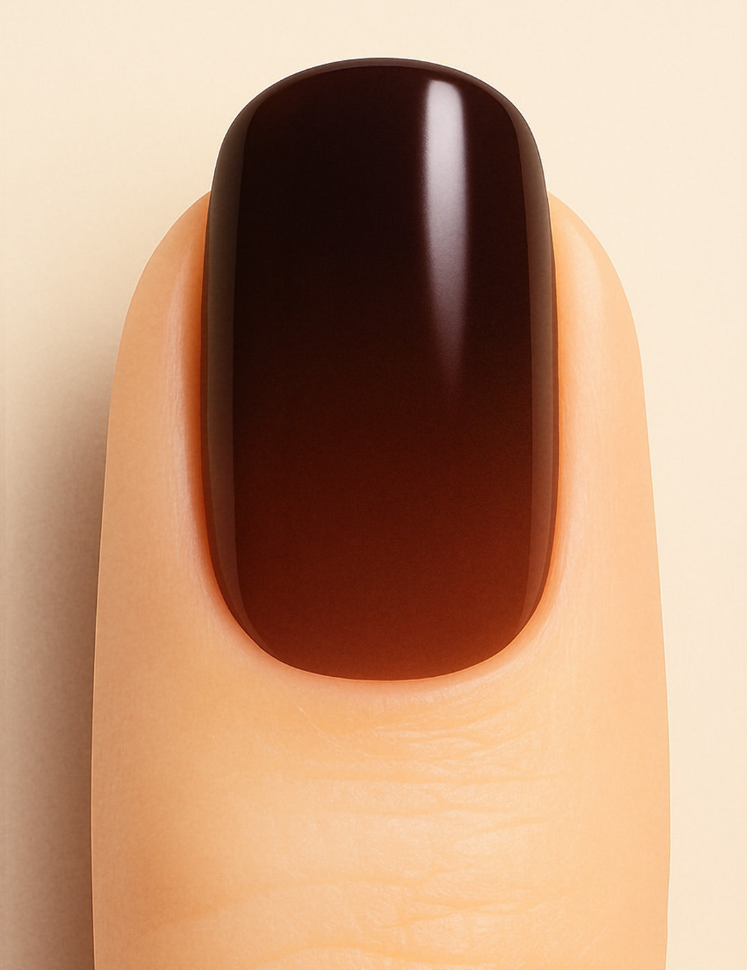 A close-up shot of a model’s finger wearing Melted Cocoa Ombre Nail Stickies, showcasing a deep gradient that transitions from warm brown at the base to rich dark cocoa at the tip, highlighting the glossy finish and sophisticated ombre effect – Muselot.