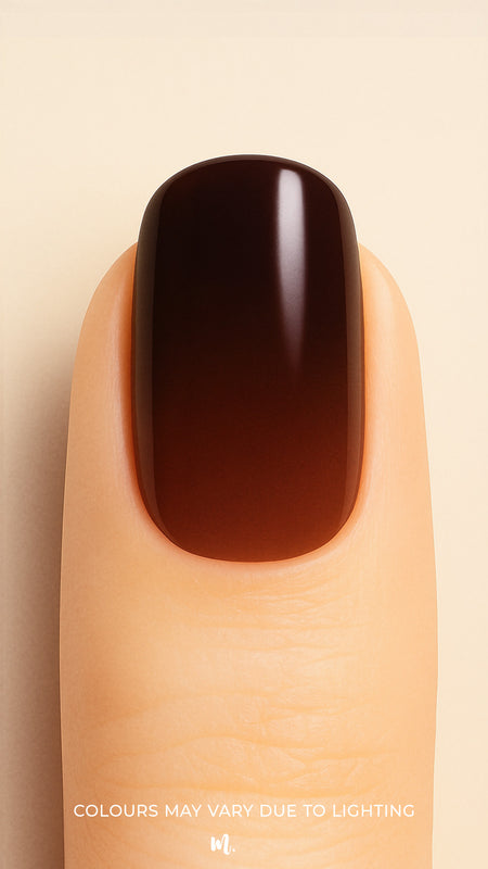 A close-up shot of a model’s finger wearing Melted Cocoa Ombre Nail Stickies, showcasing a deep gradient that transitions from warm brown at the base to rich dark cocoa at the tip, highlighting the glossy finish and sophisticated ombre effect – Muselot.