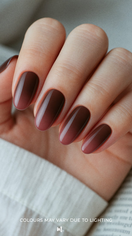 A detailed close-up of a model’s finger's wearing Melted Cocoa brown ombre nail polish stickies, showcasing the smooth gradient that blends from a soft milk-chocolate brown into a deep cocoa shade, highlighting the glossy texture and elegant salon-style ombre finish – Muselot.