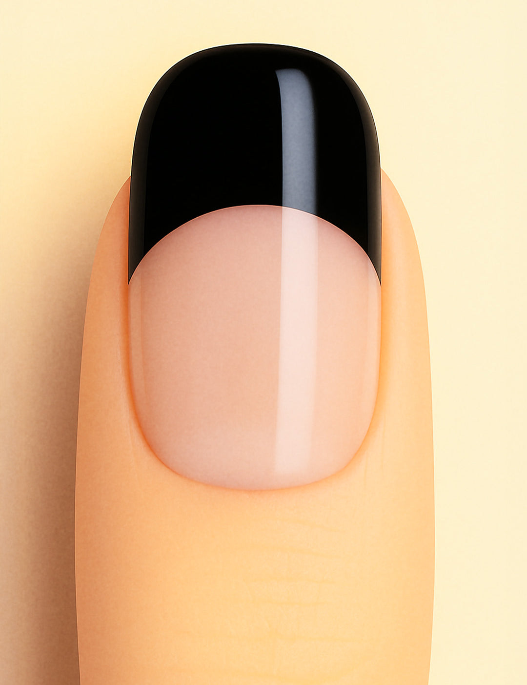 A close-up view of a finger wearing Midnight Tiara French Tip nail stickies, featuring a sleek black tip over a glossy nude base. The design highlights the timeless elegance of the French manicure with a bold, modern twist, giving a chic and sophisticated finish – Muselot.