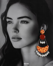 A model wearing the Mittika chandbali earrings, where warm terracotta hues and crackled orange textures blend beautifully with soft pearl droplets — offering an earthy, artistic charm that elevates any look — Muselot.