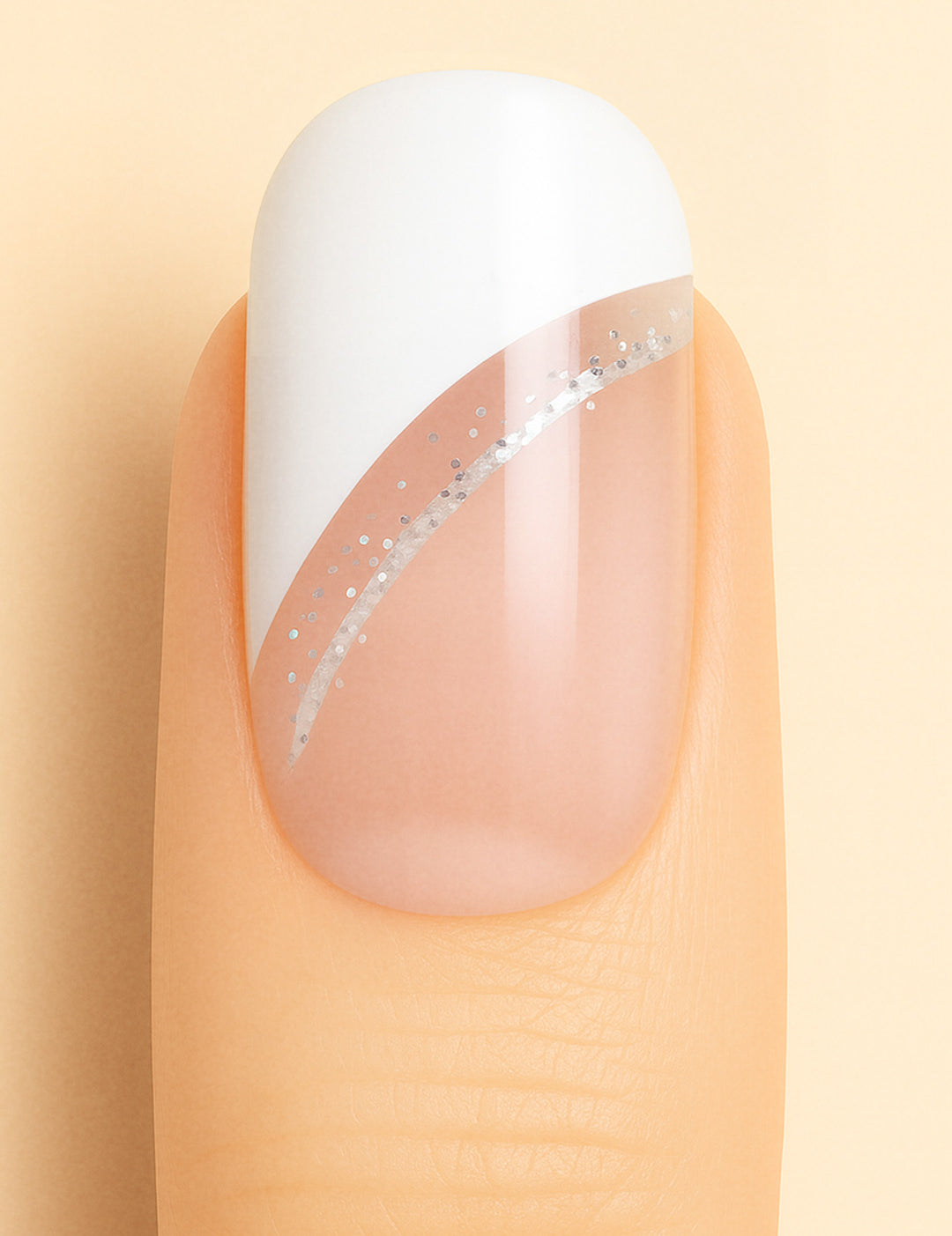 A close-up view of a single nail featuring the Moonlit Wave French Tip Nail Stickies design from Muselot. The nail has a crisp white diagonal French tip accentuated by a delicate silver glitter line, blending into a natural nude base. The glossy finish enhances the chic and modern look, perfect for elegant nail art styles.