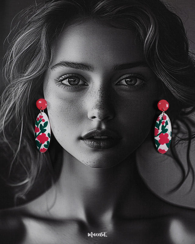 A woman wearing the Nargis handmade floral drop earrings with her hair tucked back, highlighting the vivid pink floral pattern and the glossy finish that showcases the hand-painted craftsmanship and playful elegance — Muselot.