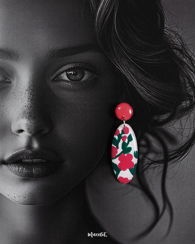 A close-up of a woman wearing the Nargis handmade floral drop earrings, highlighting the vivid pink and green floral design on white ovals, showcasing the vibrant charm and hand-painted detailing — Muselot.