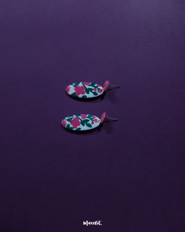 A detailed view of the Nargis pink floral drop earrings placed against a soft backdrop, showcasing the delicate design, handcrafted petals, and elegant color blend — Muselot.