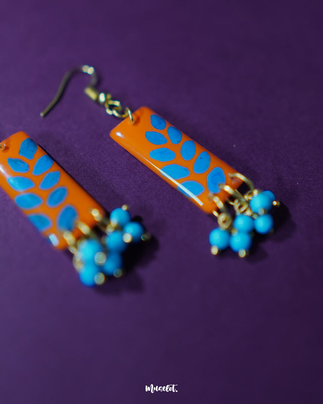 Narmshaam handmade hook earrings displayed against a soft neutral background, showcasing their delicate floral motifs, colorful hand-painted details, and lightweight artisanal design — Muselot.
