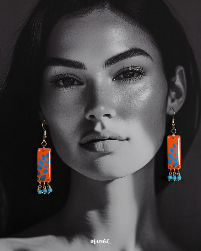A model wearing Narmshaam handmade hook earrings, showcasing the vibrant hand-painted floral detailing and lightweight design that adds a charming, artistic touch to everyday and festive looks — Muselot