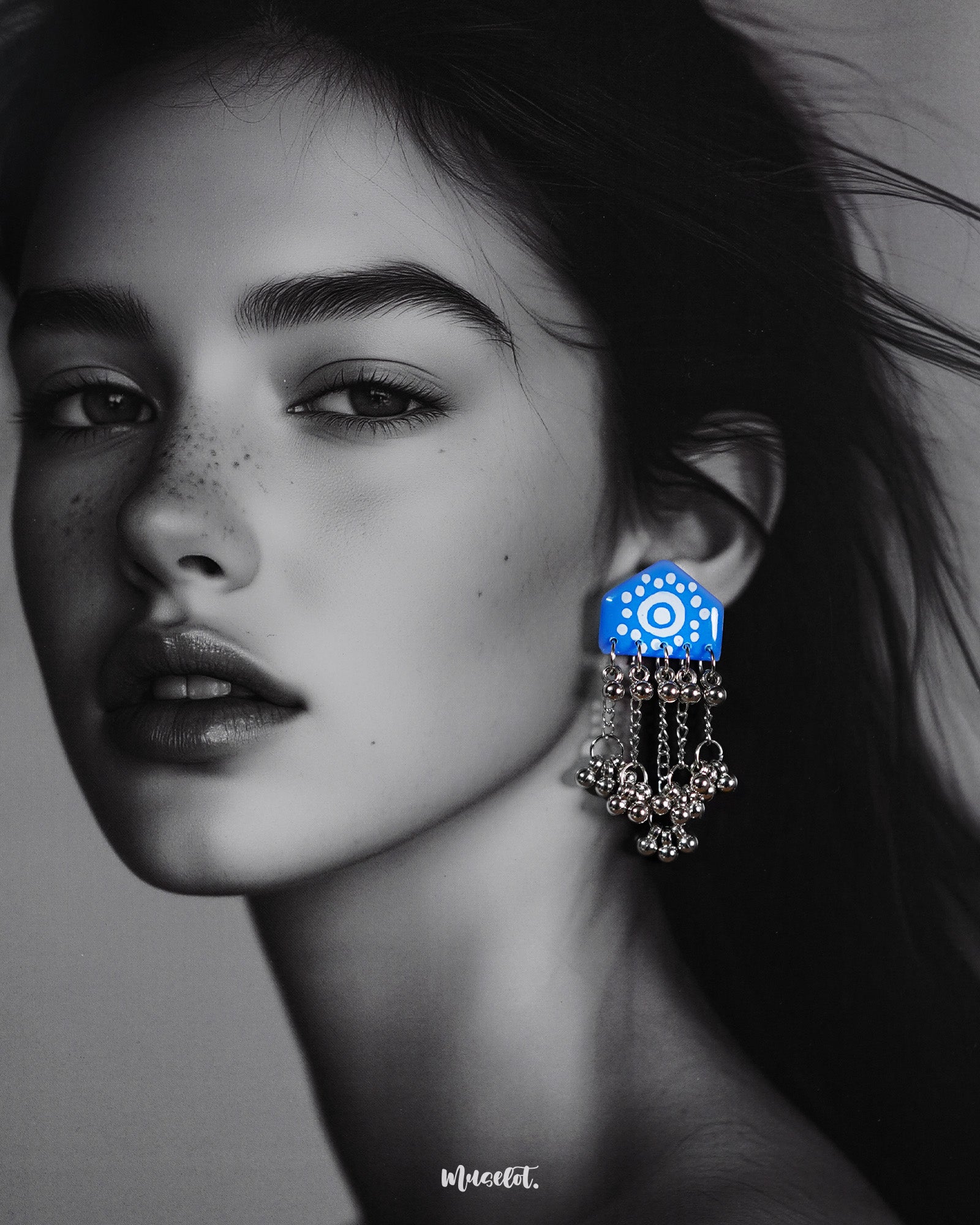Model wearing Nazafar blue handcrafted earrings, showcasing white painted motifs and cascading silver ghungroo chains for a bold ethnic look – Muselot.