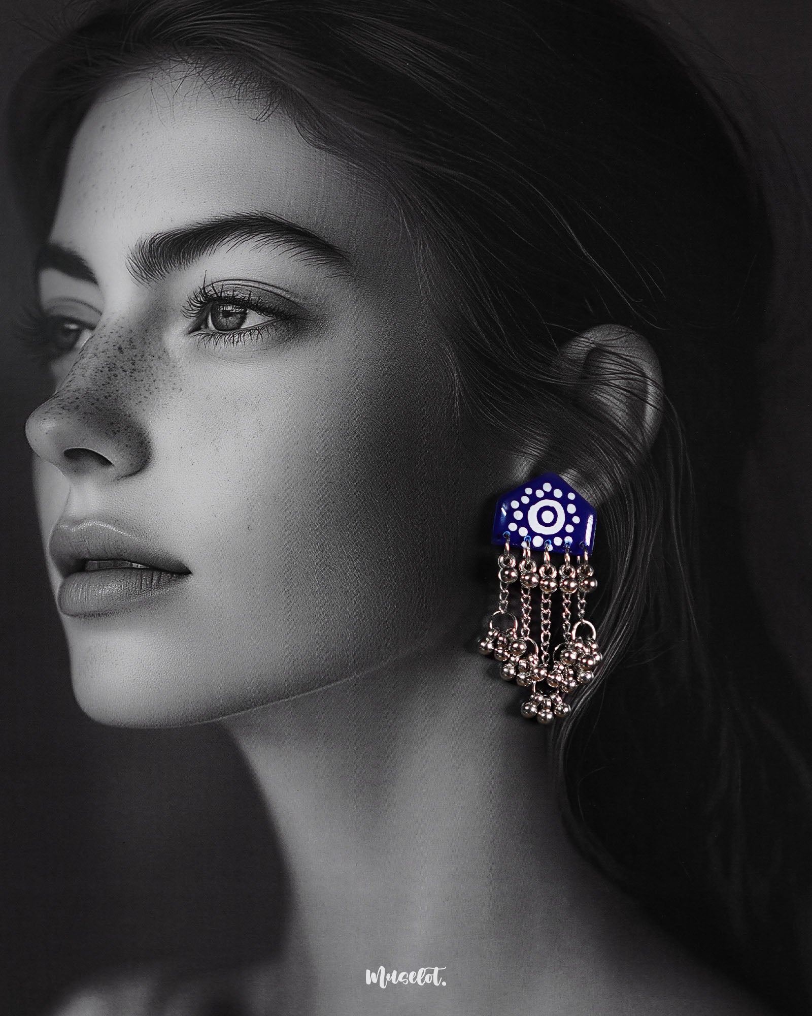 Model wearing Nazafar dark blue handcrafted earrings, showcasing white painted details and cascading silver ghungroo chains in a bold ethnic style – Muselot.