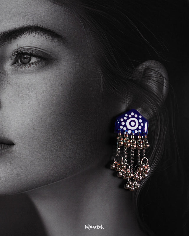 Close-up of model wearing Nazafar dark blue handcrafted earrings, highlighting the white motif work and cascading silver ghungroo chains – Muselot.