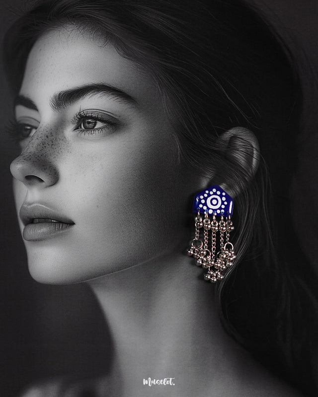 Model wearing Nazafar dark blue handcrafted earrings, showcasing white painted details and cascading silver ghungroo chains in a bold ethnic style – Muselot.