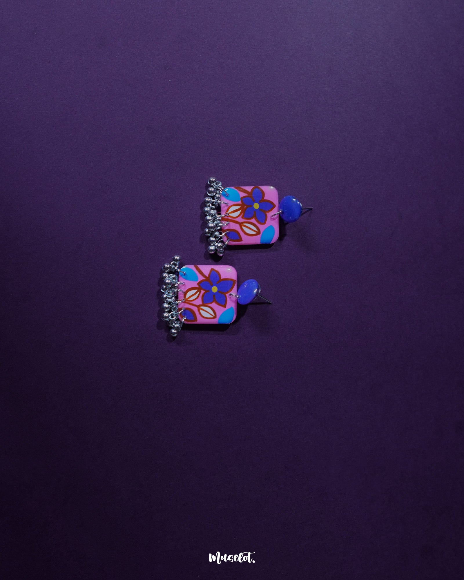 Nazmira handmade floral stud drop earrings, elegantly displayed against a rich purple background, with delicate floral details and a soft drop design that exude bohemian charm and sophistication — Muselot.