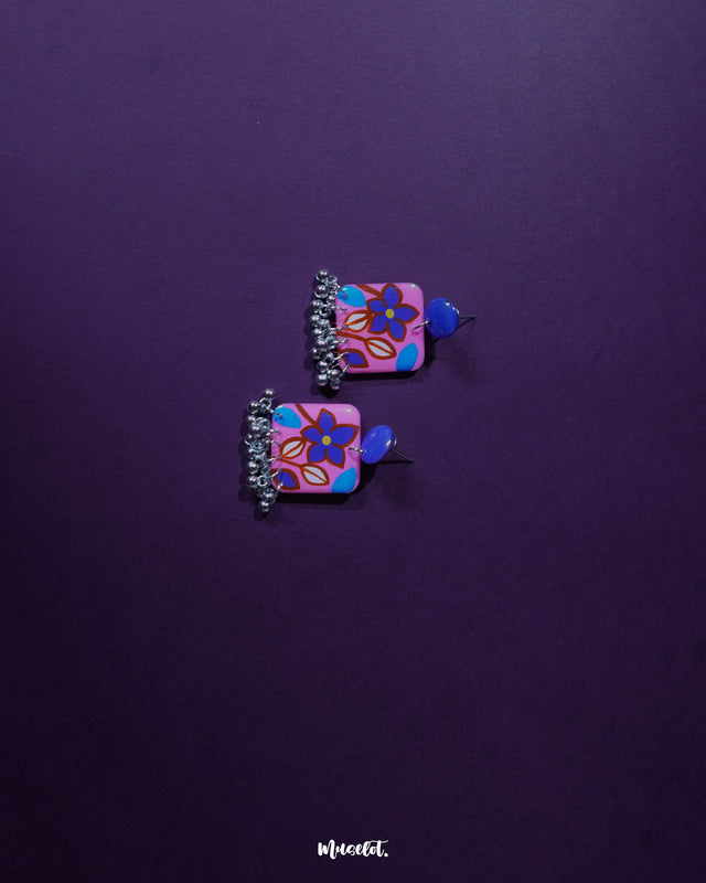Nazmira handmade floral stud drop earrings, elegantly displayed against a rich purple background, with delicate floral details and a soft drop design that exude bohemian charm and sophistication — Muselot.