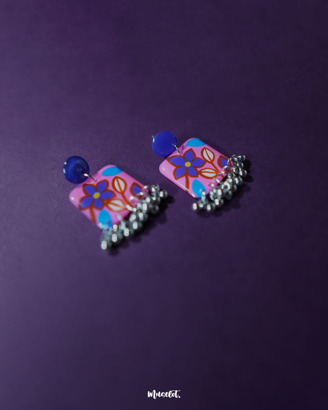 Nazmira handmade floral stud drop earrings, framed by a rich purple background, showcasing delicate floral details and an elegant drop design that bring out their boho-inspired charm — Muselot.
