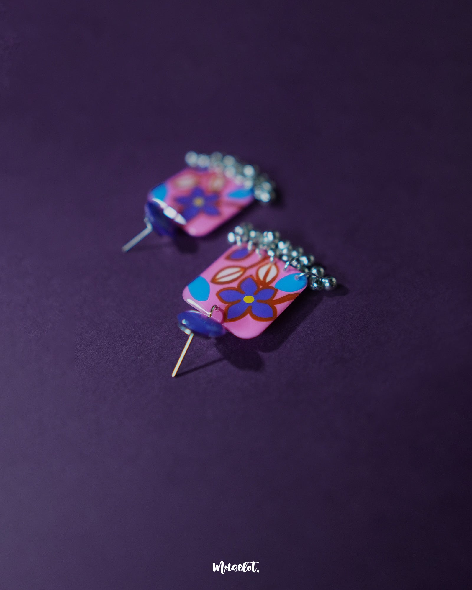 Nazmira handmade floral stud drop earrings, highlighted against a dark purple backdrop, with detailed floral studs and a graceful drop that perfectly embody bohemian elegance and artisanal craftsmanship — Muselot.