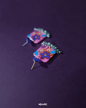 Nazmira handmade floral stud drop earrings, highlighted against a dark purple backdrop, with detailed floral studs and a graceful drop that perfectly embody bohemian elegance and artisanal craftsmanship — Muselot.