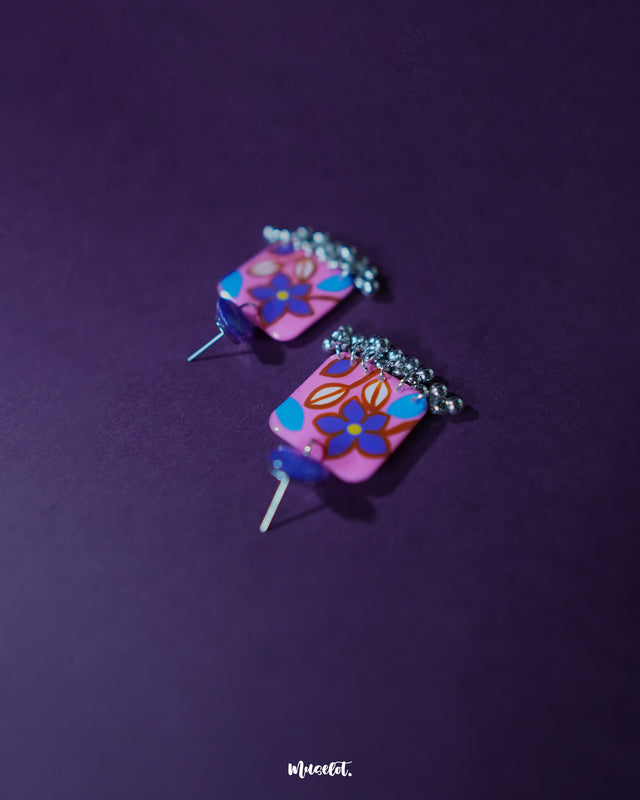 Nazmira handmade floral stud drop earrings, set against a bold purple background, with intricate floral patterns and a delicate drop design that exude a perfect blend of bohemian flair and timeless elegance — Muselot.