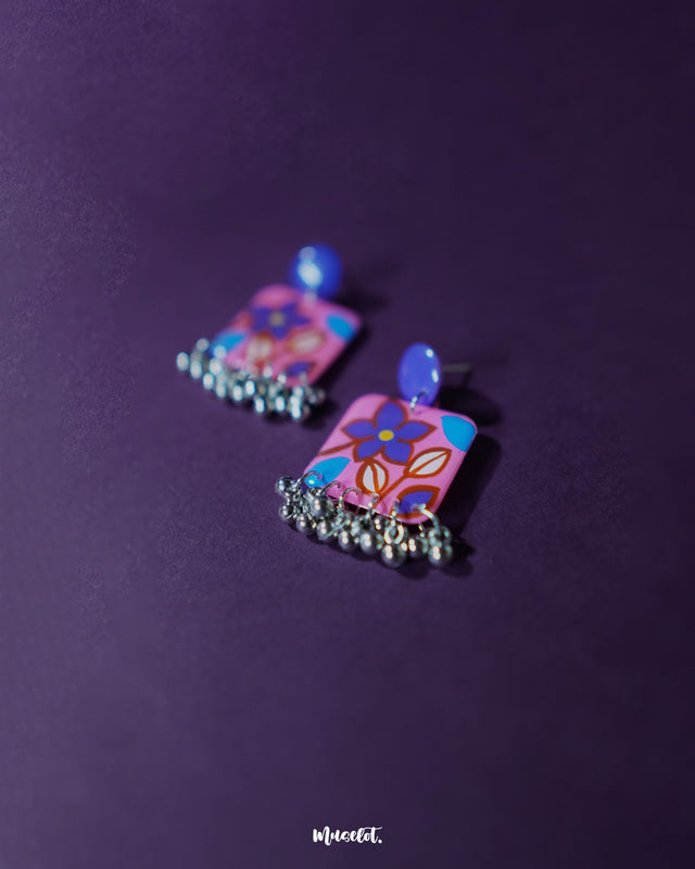 Nazmira handmade floral stud drop earrings, placed against a deep purple background, featuring finely detailed floral studs and an elegant drop that adds a sophisticated boho touch to any outfit — Muselot.