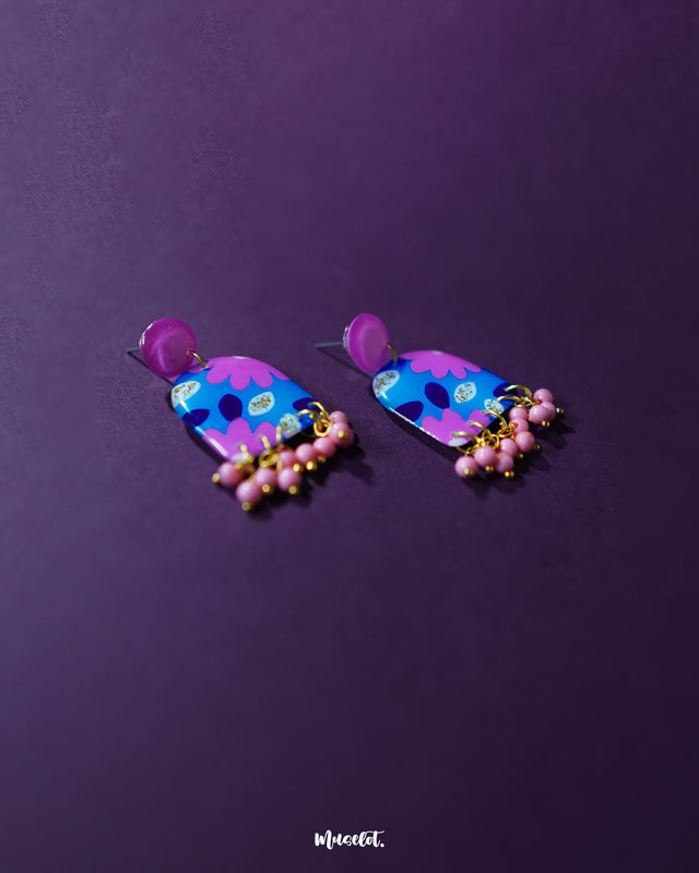 The Neelzair purple floral earrings featuring delicate floral detailing with cascading beadwork, showcasing their handcrafted charm and bohemian elegance — Muselot.