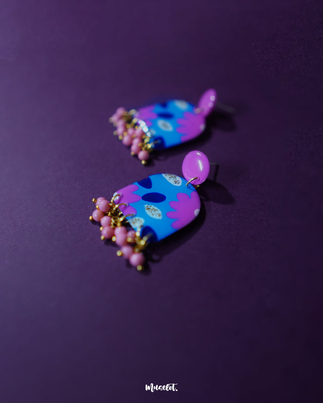 A close-up shot of the Neelzair purple floral earrings, highlighting the delicate petal arrangement and subtle shimmer, showcasing the handmade charm and elegant drop design — Muselot.