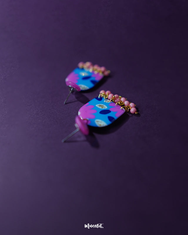 The Neelzair purple floral earrings displayed from a side angle, showcasing the vibrant floral accents and lightweight handcrafted design that add a charming statement to any look — Muselot.