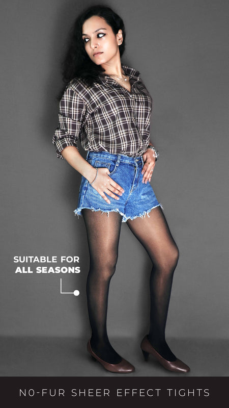 A woman wearing no fur sheer effect tights, posing with her thumbs inside the pocket of her shorts as she looks sideways, highlighting the perfect modern look-Muselot