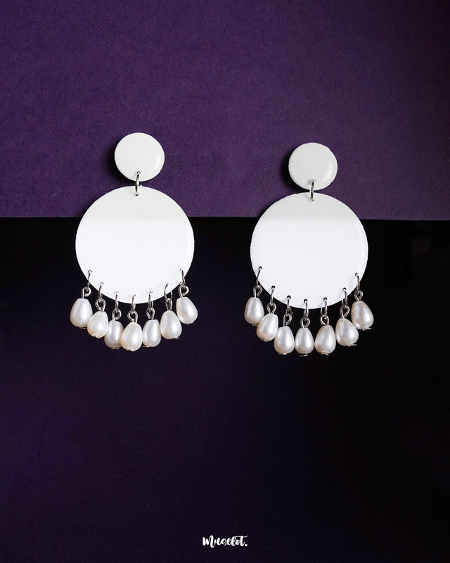 Noor chandbali earrings featuring a minimal all-white palette with delicate pearl drops, showcasing their simple elegance and handcrafted finish against a rich purple backdrop — Muselot.