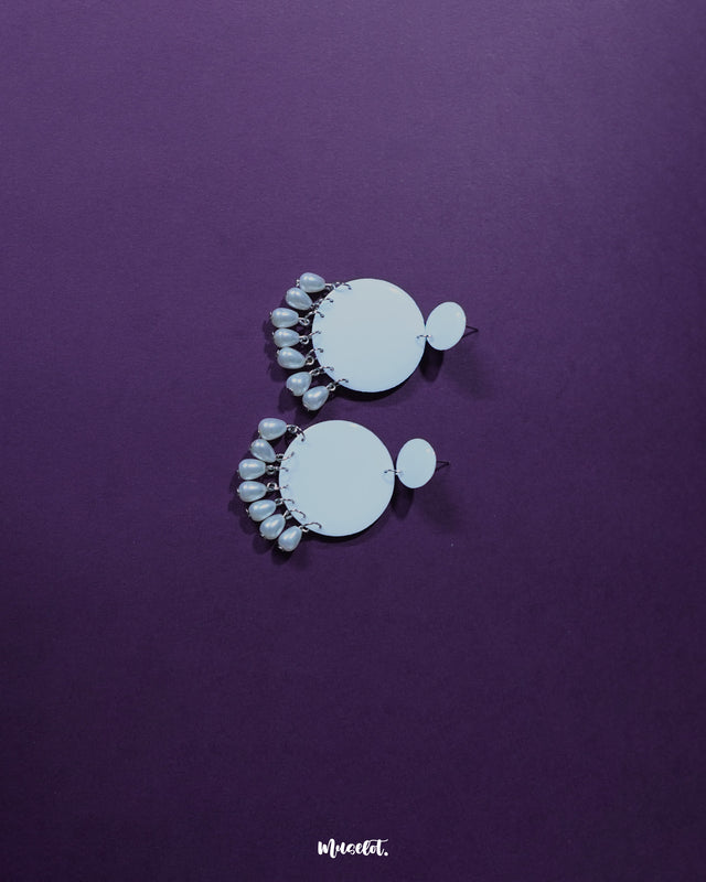 Noor white drop earrings featuring a crescent silhouette with pearl-like dangles, shown from a closer angle to highlight their graceful detailing and showcase their delicate handcrafted finish — Muselot.