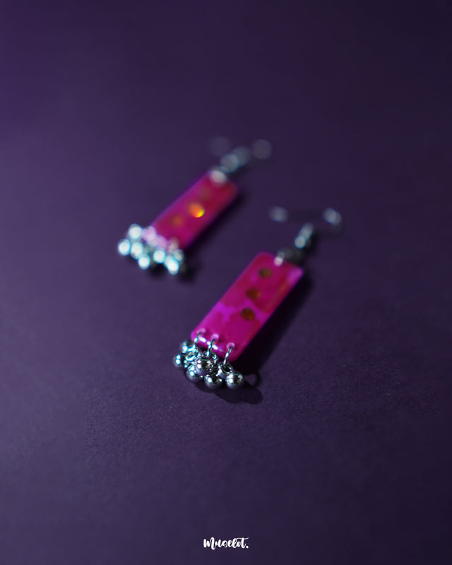 Noorasa drop earrings against a rich purple background, enhancing their elegant design – Muselot