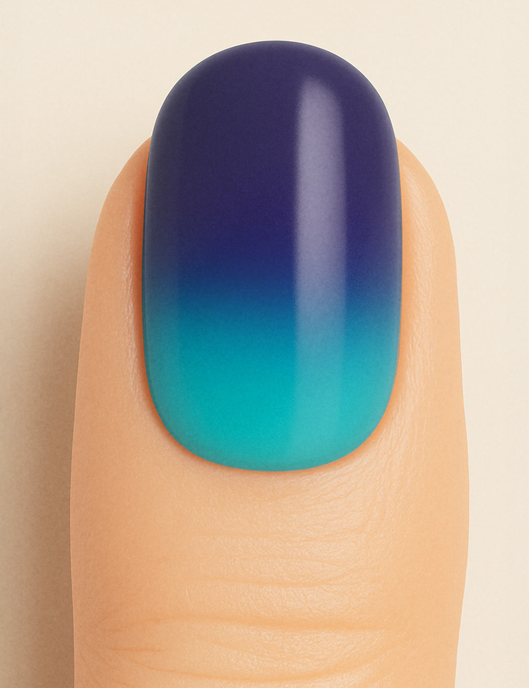 A close-up shot of a model’s finger wearing Ocean Dip Ombre Nail Stickies, showcasing a smooth gradient that blends deep navy blue into aqua teal, highlighting the ocean-inspired tones and glossy salon-like finish that make ombre nails stand out – Muselot.