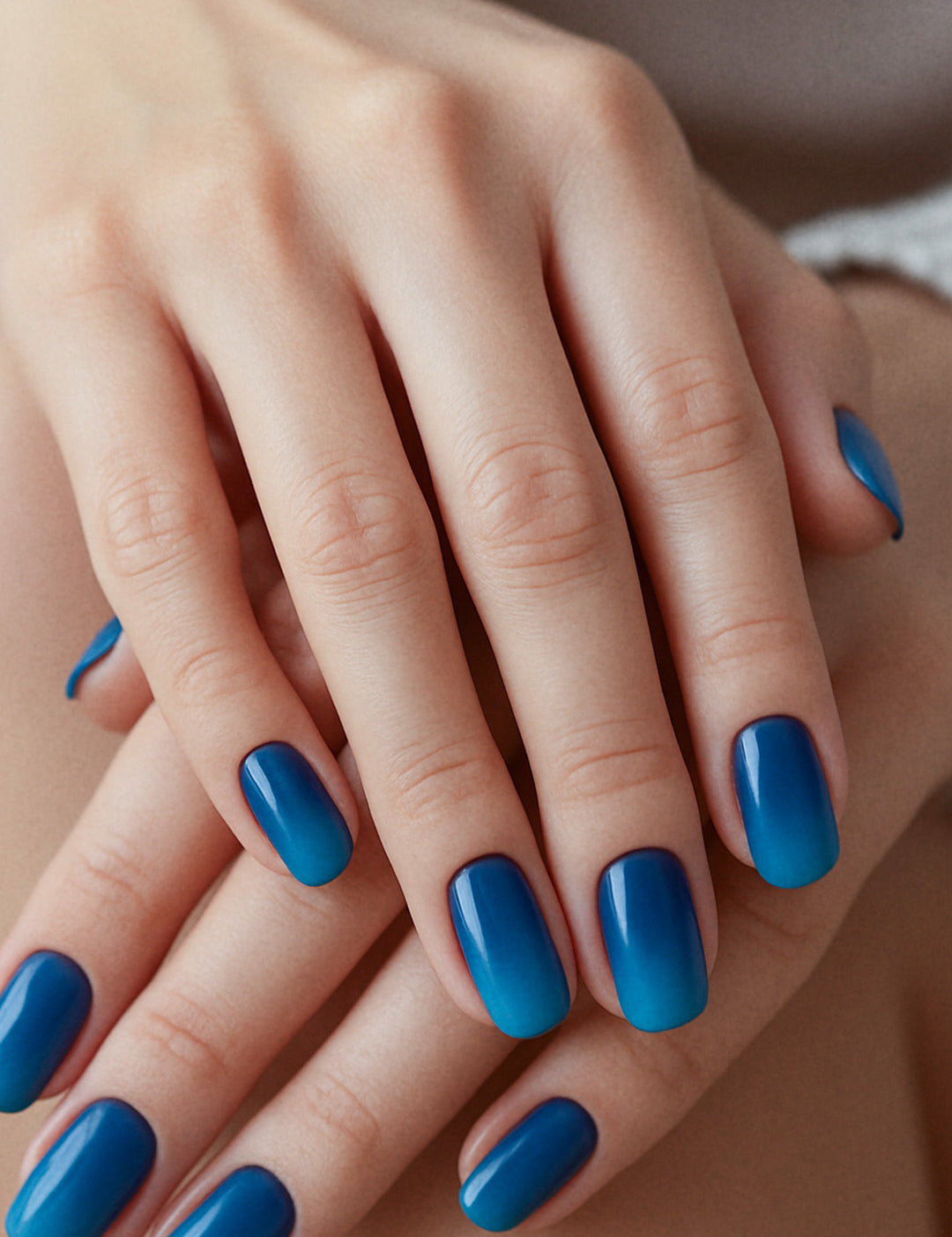 A model’s hand styled with Ocean Dip Ombre Nail Stickies, showcasing a seamless gradient from deep navy blue to vibrant aqua teal, highlighting the bold contrast of ocean-inspired tones while adding a sleek, glossy finish that elevates simple nail art into a polished statement – Muselot.