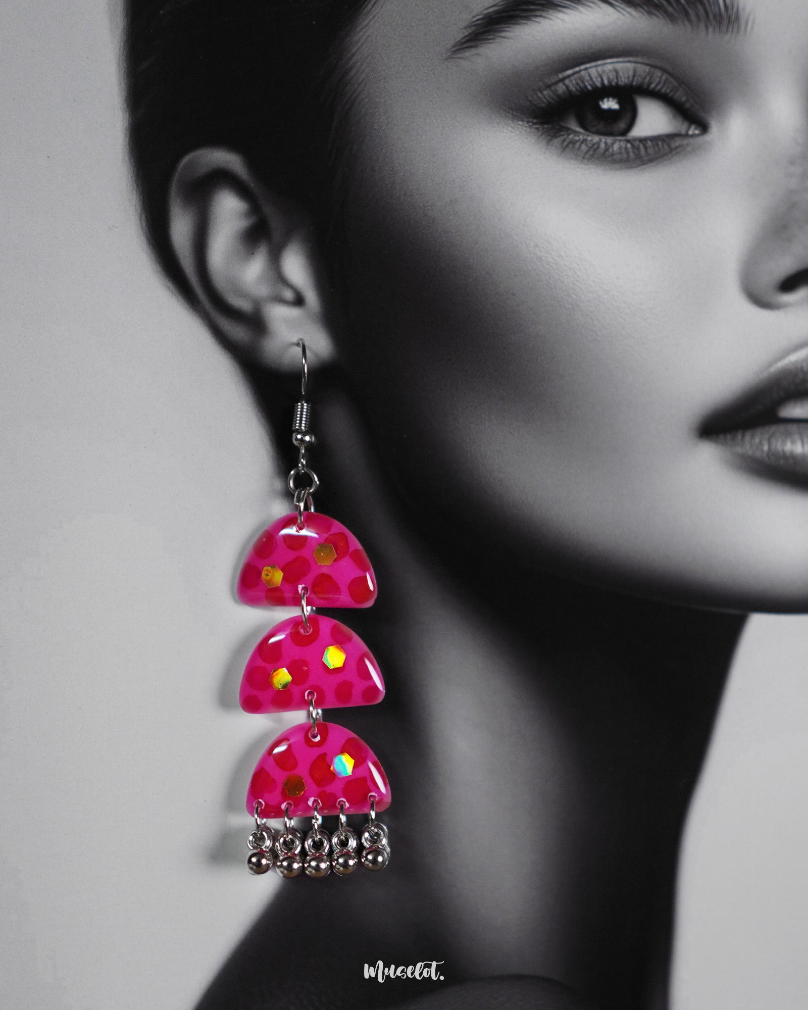 Close-up shot of a woman wearing Parvaaz handmade pink drop earrings, showcasing the intricate floral detailing and soft pastel hues that highlight the earrings’ gentle charm and artistic craftsmanship — Muselot.
