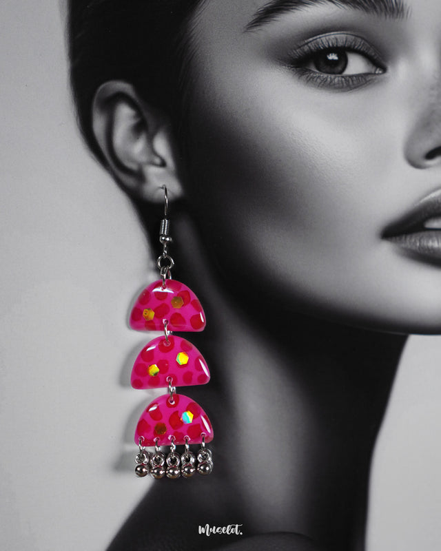 Close-up shot of a woman wearing Parvaaz handmade pink drop earrings, showcasing the intricate floral detailing and soft pastel hues that highlight the earrings’ gentle charm and artistic craftsmanship — Muselot.