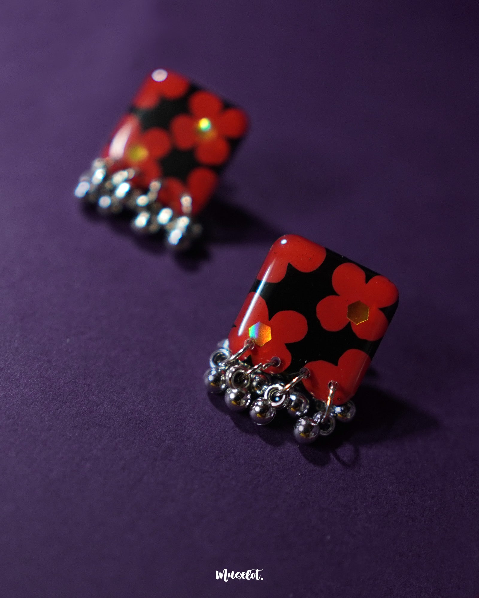 A pair of exquisite Raktphool stud earrings, designed with intricate floral patterns that add a touch of elegance, showcasing the delicate craftsmanship of the earrings, making them a perfect choice for any occasion — Muselot.