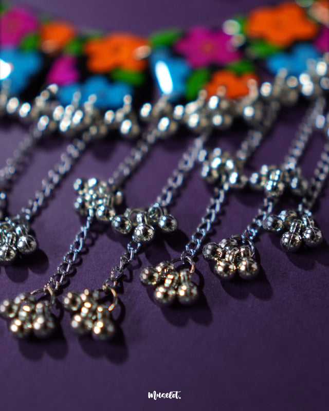 Close-up shot of the Rangbaagh black floral necklace set focusing on the gunghroo-style chain detailing, highlighting the metallic texture, subtle shine, and traditional handcrafted elements that lend charm and movement to the design — Muselot.