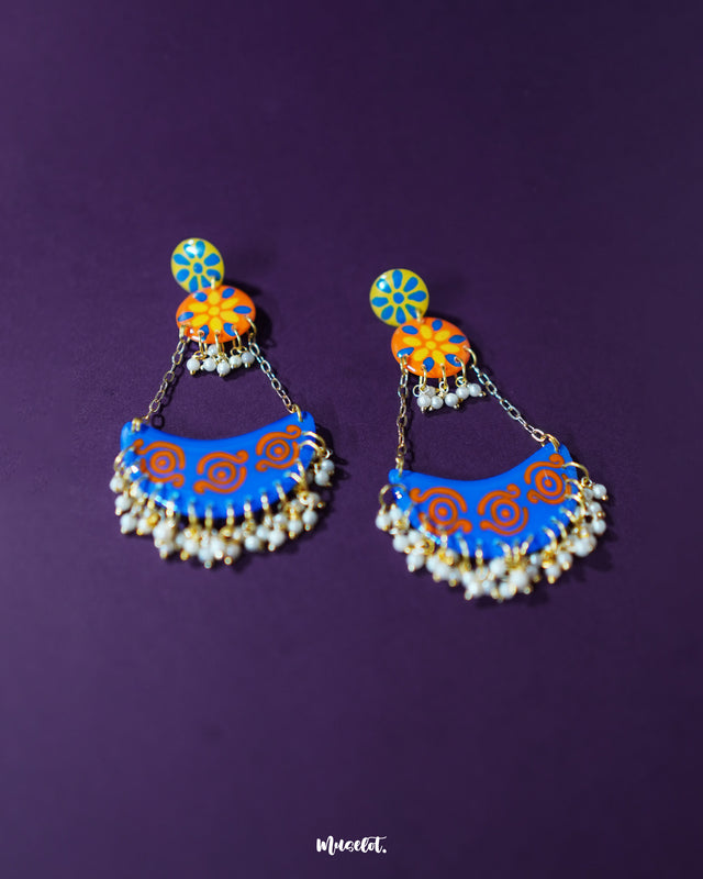 A detailed view of the Ranglahar blue chandbaali earrings showcasing the crescent-shaped design adorned with delicate pearl hangings, bold orange accents, and finely painted blue enamel—an elegant fusion of tradition and statement style — Muselot.