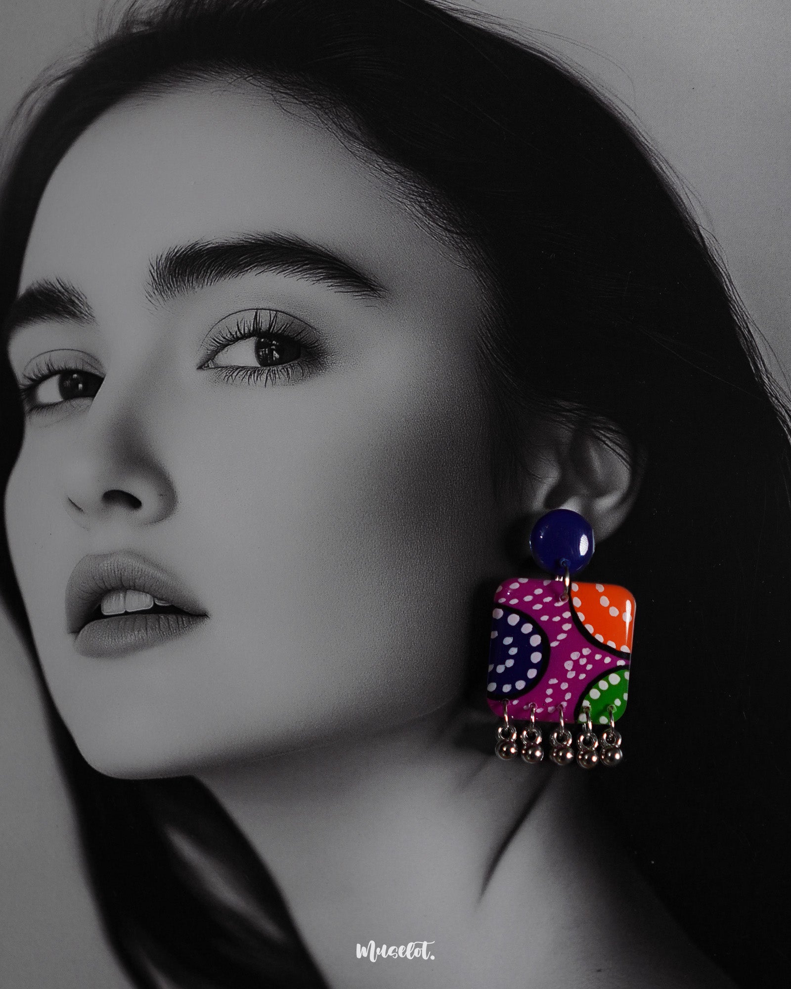 Close-up shot of a model wearing Rangras folk art stud earrings, showcasing vibrant colors and intricate folk art patterns that bring a blend of traditional charm and modern elegance to the look — Muselot.