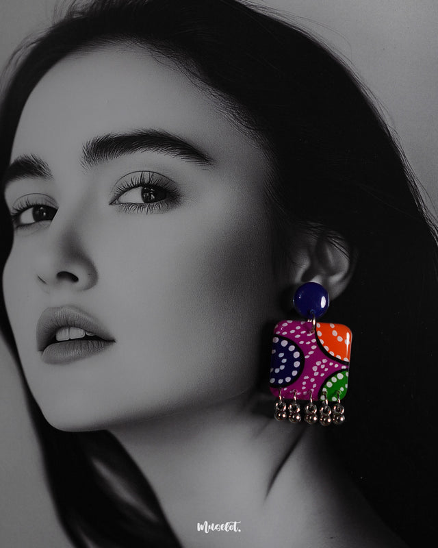 Close-up shot of a model wearing Rangras folk art stud earrings, showcasing vibrant colors and intricate folk art patterns that bring a blend of traditional charm and modern elegance to the look — Muselot.