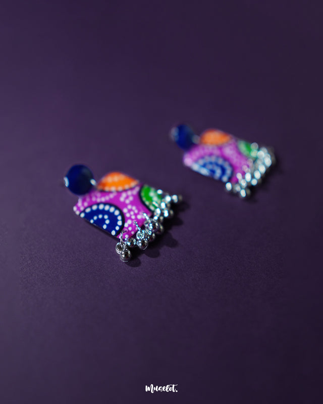 Rangras stud earrings, set against a rich purple background, featuring intricate folk art patterns and vibrant colors that showcase a perfect blend of traditional craftsmanship and modern elegance — Muselot.