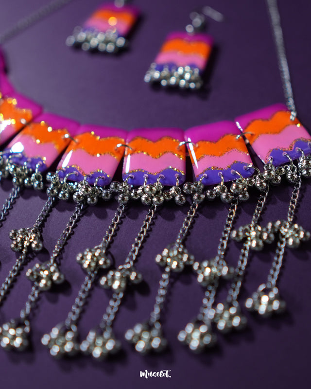 The Rangrezan handmade colorful necklace set is laid out to showcase its vibrant beads, shimmering metallic accents, and playful ghungroos — a boho statement piece that celebrates handcrafted charm — Muselot.